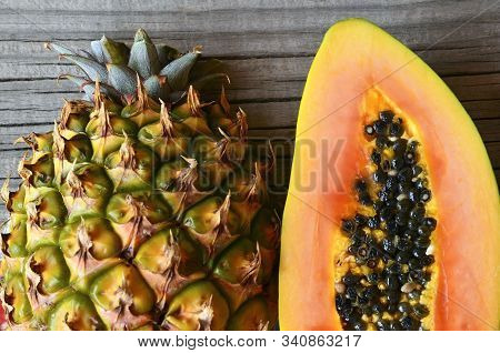 Ripe Organic Papaya And Pineapple Tropical Fruit Cut In Half On Old Wooden Table.healthy Eating,diet