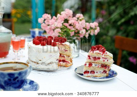 Laid Holiday Table In The Summer Garden. Cake, Cups, Glasses With Liquor And A Decanter On A Table W