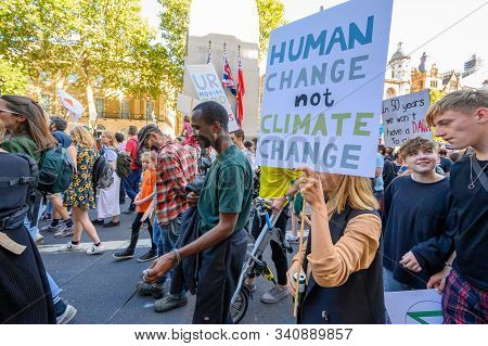 LONDON - SEPTEMBER 20, 2019: Climate Change protester carrying a homemade protest placard past The Cenotaph on Whitehall, London at an Extinction Rebellion march