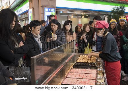 Osaka, Japan- 27 Nov, 2019: Vendor Making Takoyaki On A Takoyaki Pan In Osaka, Japan. Takoyaki Is Fa