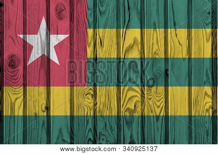Togo Flag Depicted In Bright Paint Colors On Old Wooden Wall. Textured Banner On Rough Background