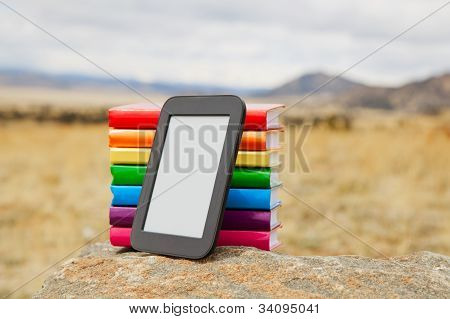 Pile de livres imprimés avec le lecteur de livre électronique