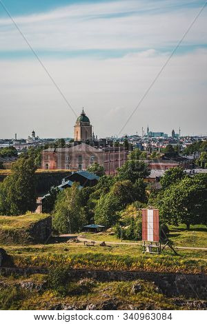 Suomenlinna Sea Fortress With The Old Buildings And Lighthouse With Helsinki City In The Background 