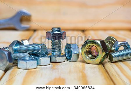 New Few Metal Nuts And Bolts On Wood Boards Close Up
