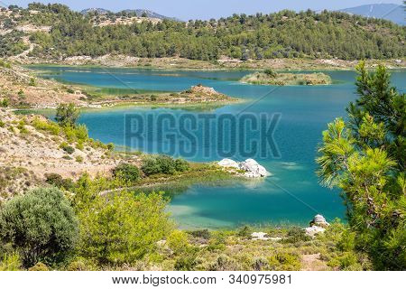 Scenic View At The Gadoura Water Reservoir On Rhodes Island, Greece With Blue And Turquoise Water An
