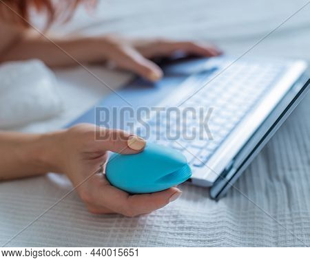 A Woman Lies In Bed Holding A Clitoral Vibrator And Watching Porn On A Laptop. The Girl Has Sex Onli