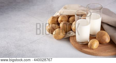Vegan Friendly Potato Pilk In Glasses On Gray Table. Alternative Plant Based Milk And Potato Tubers.