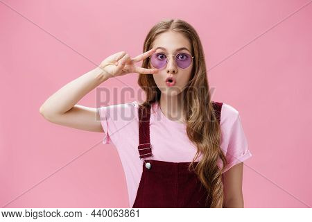 Portrait Of Stylish Energetic Girl With Scar On Hand Showing Peace Sign Over Eye Wearing Cool Sungla