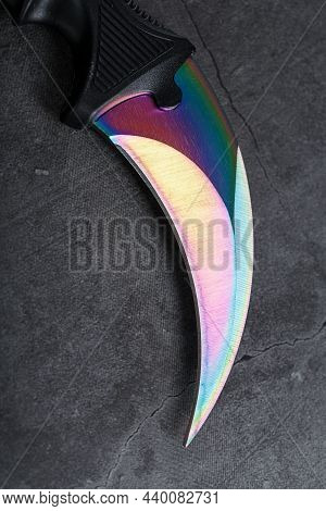 A Dagger With A Steel Blade With A Gradient Color On A Black Background.
