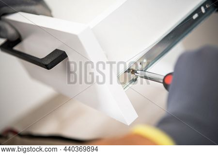 Cabinetmaker Finishing Kitchen Cabinets Assembly Close Up. Furnishing Theme.