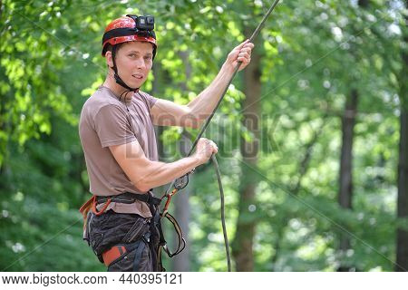 Man Belays His Partner Climber With Belaying Device And Rope. Climbers Handsman Holding Equipment Fo