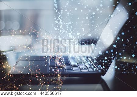 Close Up Of Laptop On Desktop With Abstract Polygonal Spheres On Blurry Office Background. Futuristi