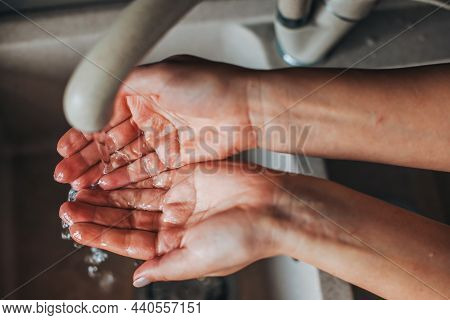 Close Up Portrait Of Womans Hand, Washing Her Hands Under Tap Water Of Basin. Coronavirus. Pandemic 