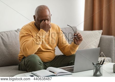 Senior Man Rubbing Nosebridge Having Eyesight Problems And Headache Indoors