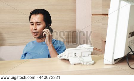 Nurse Man Sitting In Counter Bar Office Calling Smartphone Talking To Patient, Nurse Using Phone Cal