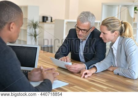 couple signing contract with real estate agent