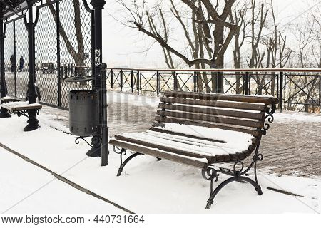 Wooden Bench In The Park In The Snow In Winter. Winter Bench Under A Layer Of Snow After A Snowfall 