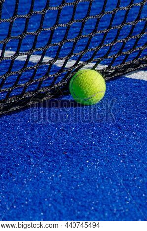 Ball Next To The Net On A Blue Paddle Court