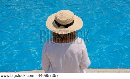 Senior Woman Relaxing Near The Hotels Blue Outdoor Swimming Pool. People Are Enjoying Their Summer V