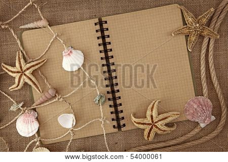 Fishing net and exercise book on brown background