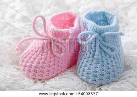 Blue and pink baby booties on white background
