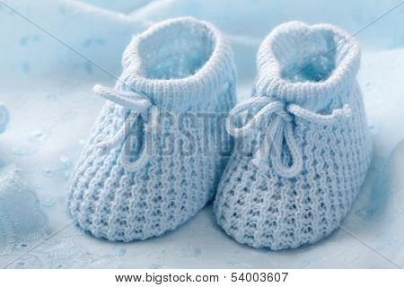 Blue baby booties on blue background