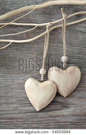Two wooden hearts on grey background