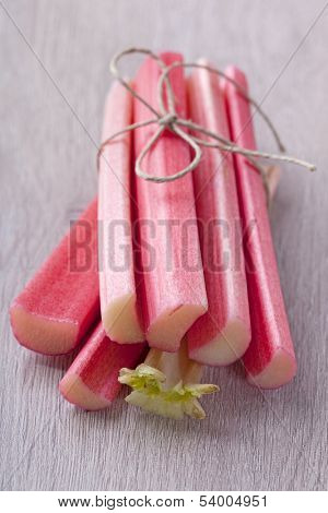 Bunch of fresh rhubarb on wooden background