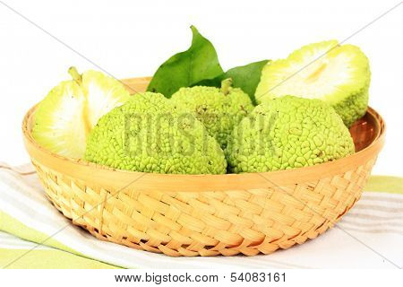 Osage Orange fruits (Maclura pomifera) in basket, isolated on white