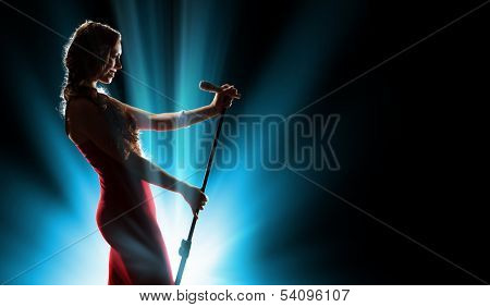 Female singer on the stage holding a microphone
