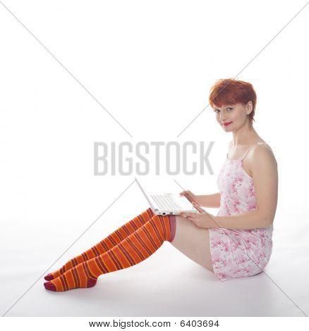 Red meisje in stripe sokken met laptop op witte achtergrond