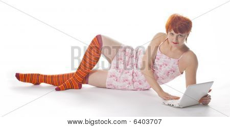 Red meisje in stripe sokken met laptop op witte achtergrond