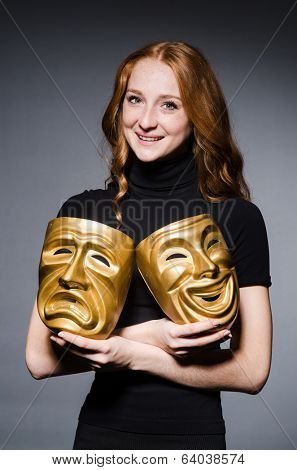 Redhead woman iwith masks in hypocrisy consept against grey background