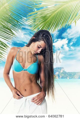 Young woman reaxing on the beach at exotic resort