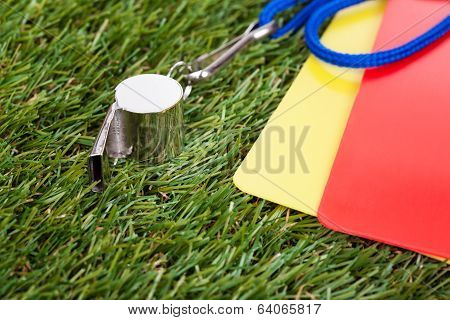 Whistle With Red And Yellow Card On The Field
