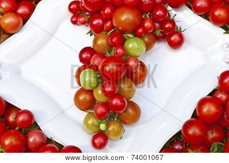 Small red tomatoes on a white plate