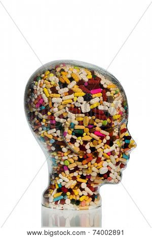 a head made of glass filled with many tablets. photo icon for drugs, abuse and addiction tablets.