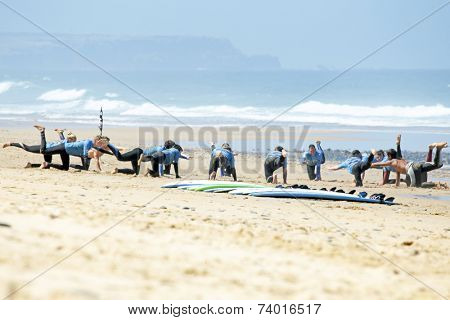 VALE FIGUEIRAS, PORTUGAL - August 16 2014:  Surfers doing excersises on the famous surfers beach Vale Figueiras in Portugal