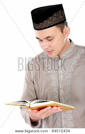 Young Muslim Man Reading A Quran