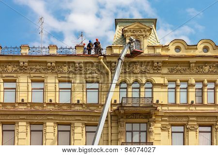 Builders on scaffolding for restoration ancient building in St. Petersburg, Russia