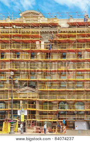 Builders on scaffolding for restoration ancient building in St. Petersburg, Russia