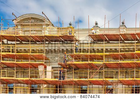 Builders on scaffolding for restoration ancient building in St. Petersburg, Russia