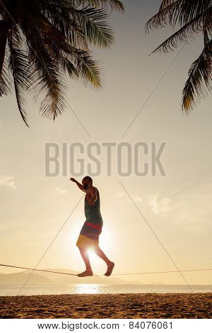 Teenage Balancing On Slackline On The Beach