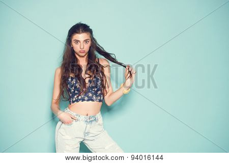 portrait of cheerful fashion hipster girl going crazy making funny face and dancing. Blue color back