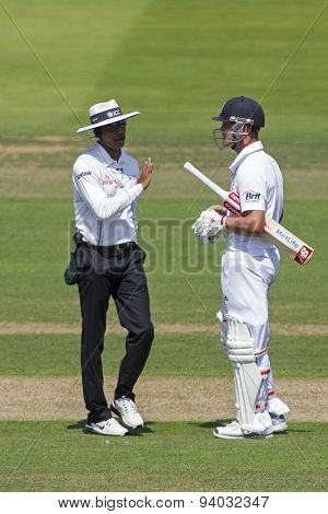 LONDON, ENGLAND - July 18 2013: umpire Kumar Dharmasena puts his hand up to avoid a conversation with Jonathan Trott on day one of the Investec Ashes 2nd test match, at Lords Cricket Ground