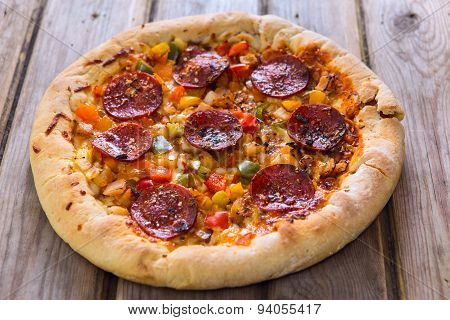 Delicious Baked Salami Pizza Served On Rustic Wooden Table