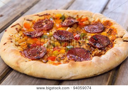 Delicious Baked Salami Pizza Served On Rustic Wooden Table