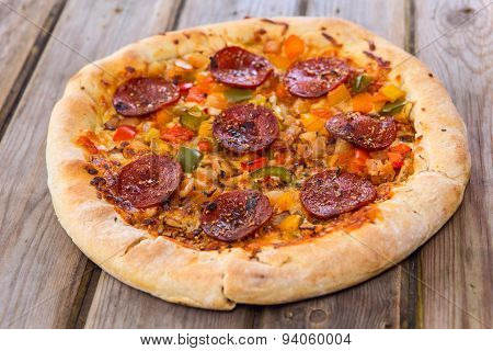 Delicious Baked Salami Pizza Served On Rustic Wooden Table