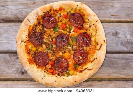 Delicious Baked Salami Pizza Served On Rustic Wooden Table
