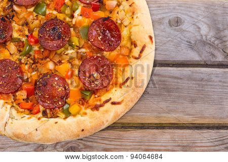 Delicious Baked Salami Pizza Served On Rustic Wooden Table